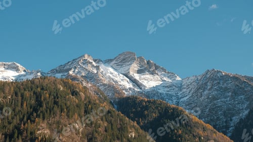 Preview: Snow-capped mountains under a clear blue sky