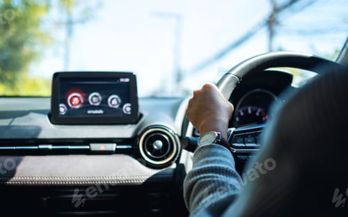 Preview: Closeup image of a woman holding steering wheel while driving a car on the road