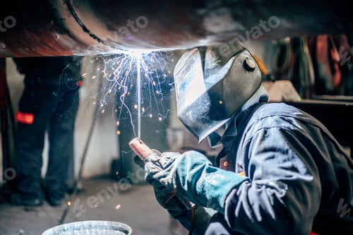 Preview: Shallow focus of a welder wearing a protective helmet and welding steel in a factory