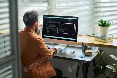 Preview: Caucasian Young Adult Man Developing Neural Network Code on Desktop Computer