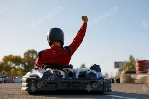 Preview: Happy go-cart driver raising hand up rejoicing and celebrating win