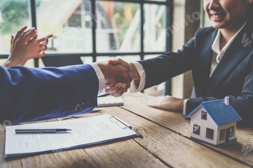 Preview: Estate agent shaking hands with customer after contract signature after completing negotiations to b
