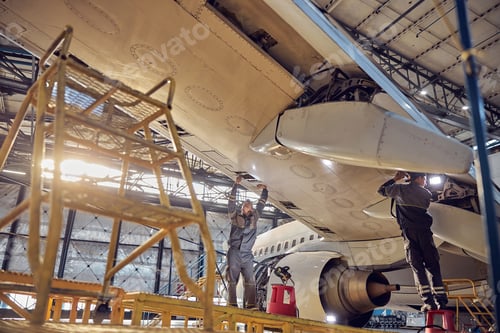 Preview: Men mechanics repairing of wing and engine of the aircraft in the hangar