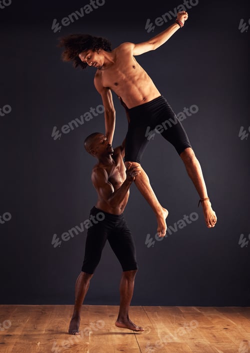 Vista previa: Two male contemporary dancers performing a dramatic pose in front of a dark background