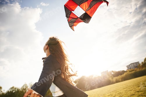 Preview: Beautiful sunlight. Happy little girl is playing with kite on the summer field