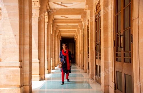 Preview: Young female tourist walking between arches and Pillars.