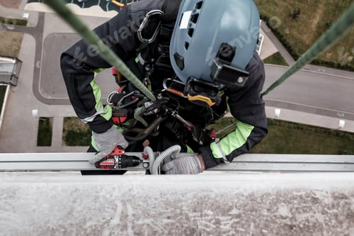Preview: Industrial mountaineering worker hangs over residential building