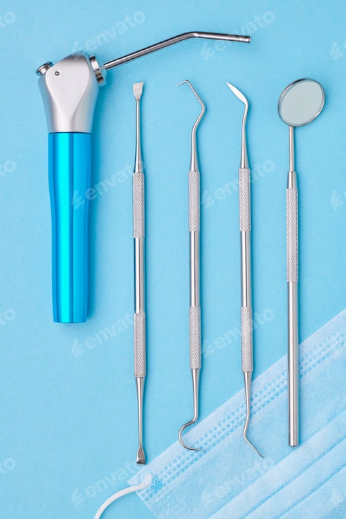 Preview: Dentist tools over blue background top view