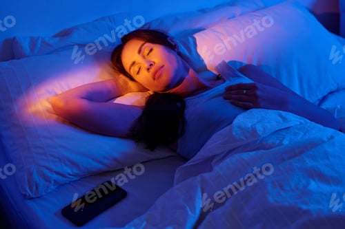 Preview: Woman Sleeping Peacefully in Bed with Phone