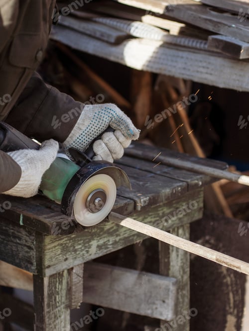 Preview: A man saws fittings with an angle grinder. Sparks fly in all directions
