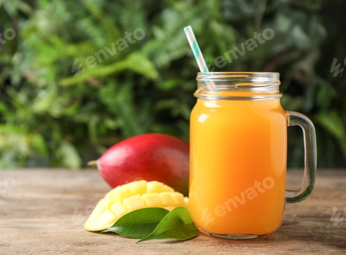 Preview: Mason jar of delicious mango drink on wooden table. Space for text