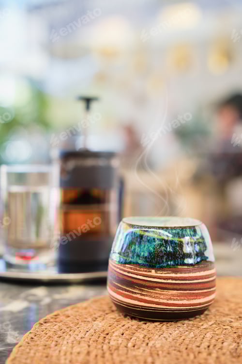 Visualização: Foto vertical, close-up da xícara de chá em uma mesa em um café