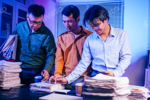 Preview: Three young businessmen work together on laptops in the office at night. They are stressed tired