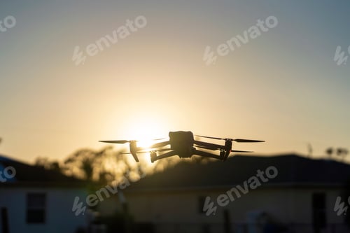 Preview: Drone aircraft with blurred fast rotating propellers and video camera flying in air