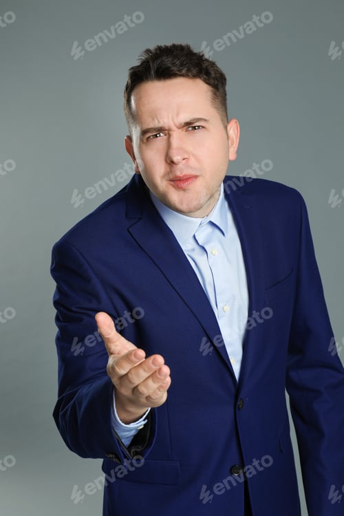 Preview: Portrait of emotional young businessman on grey background