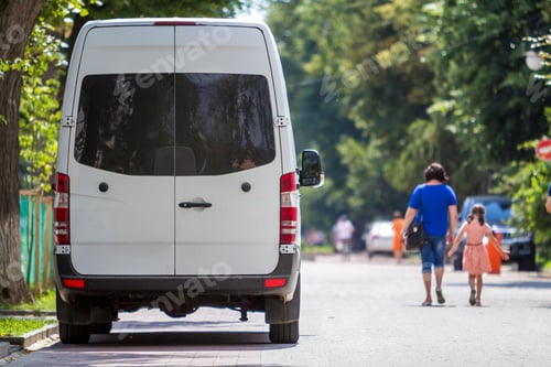 Preview: Back view white passenger medium size commercial luxury minibus van parked on summer city street.