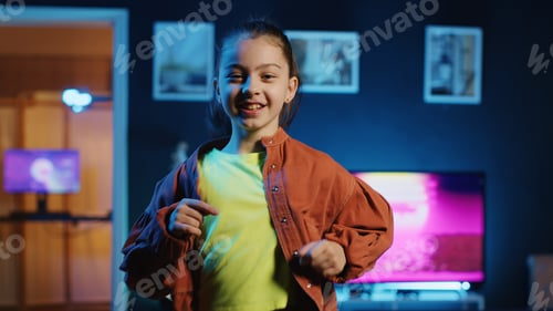 Preview: Kid dancing in dimly lit home studio interior, producing content with smartphone on tripod