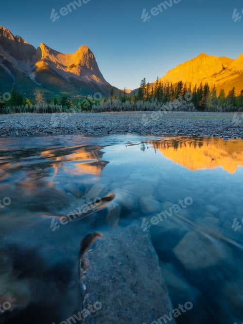 Preview: Landscape during sunrise. Autumn trees on the river bank. Mountains and forest.