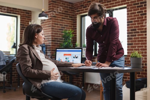 Preview: Financial agency office worker informing pregnant project manager about excellent results