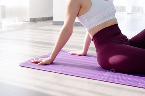 Preview: Cropped photo of young woman sitting on a yoga mat close up
