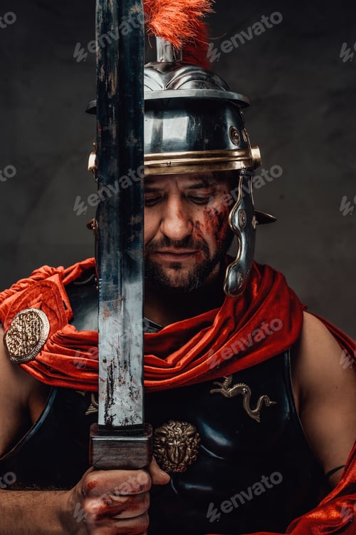 Preview: Serious roman warrior posing with sword in dark background