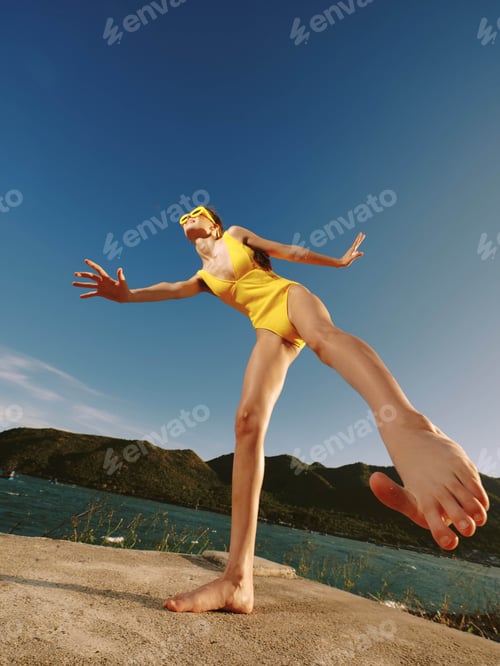 Preview: Woman, yellow swimsuit, handstand, rock, water, mountains a woman in a yellow swimsuit performs a