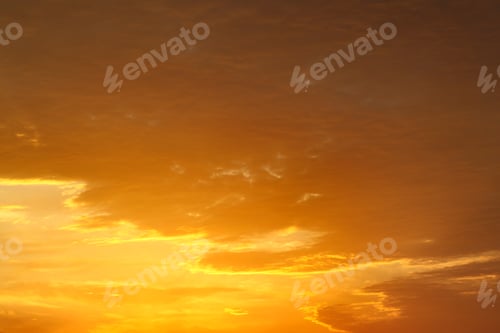 Preview: Bright orange and yellow colors of sunset sky with thick clouds.
