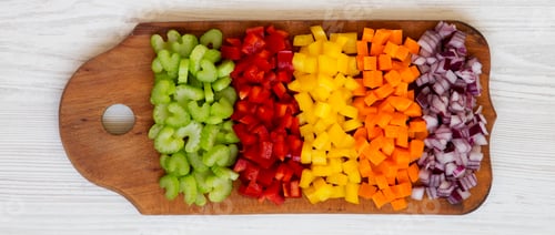 Preview: Chopped fresh vegetables (carrot, celery, red onion, colored peppers) arranged on cutting board