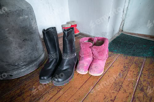Preview: Kids old winter boots laying on the wooden floor