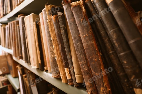 Preview: Different old books on shelf in library, closeup