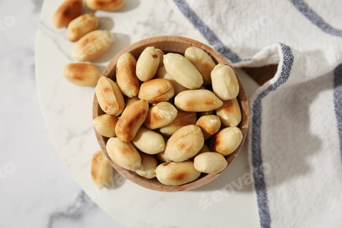 Preview: Roasted peanuts in bowl on white marble table, top view