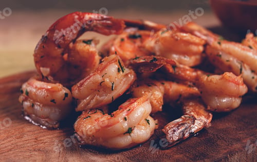 Preview: fried tiger prawns, jumbo, in garlic sauce, in butter, with herbs, on a wooden board, homemade,