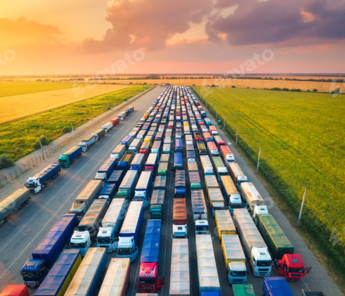Preview: Aerial view of colorful trucks in terminal at sunset in summer