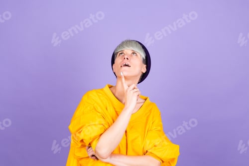 Preview: Stylish european woman on purple background thinking worried looking aside concerned