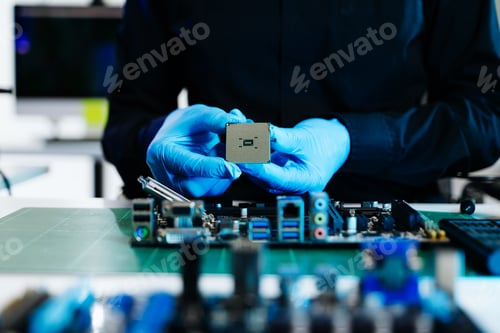 Preview: Technician in gloves installing CPU processor on computer motherboard, showcasing