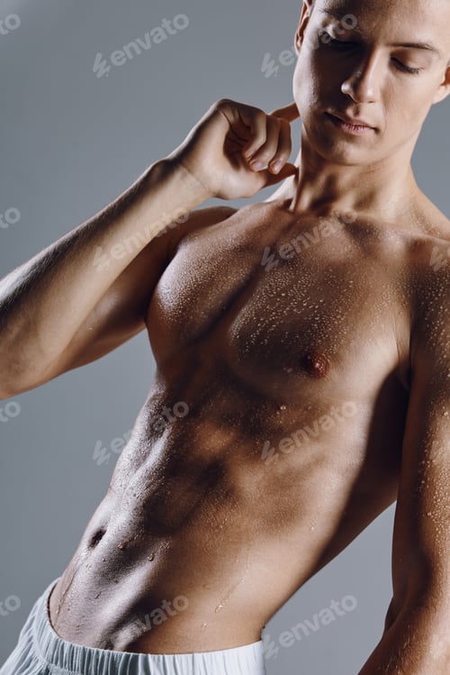 Preview: man with a pumped-up torso on a gray background posing biceps bodybuilder model