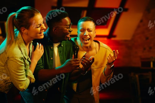 Preview: Happy friends singing and having fun while gathering on a night party at the bar.