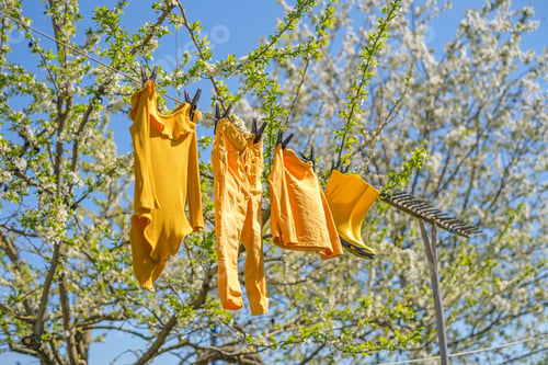 Preview: Baby clothes and boots hang on a string after washing and dry in the sun and wind
