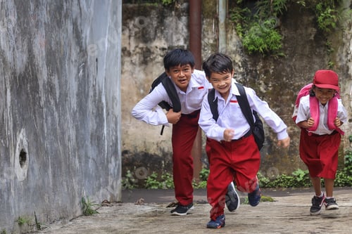 Preview: Primary school kids running on a walkway outside school building