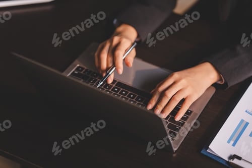Preview: Close-up of young woman's hand typing on laptop computer keyboard and surfing internet on desk, onli