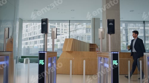 Preview: Employee walking automatic gates with coffee takeaway greeting to coworker.
