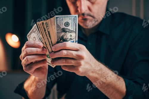 Preview: A well-dressed businessman counting american dollars at office desk