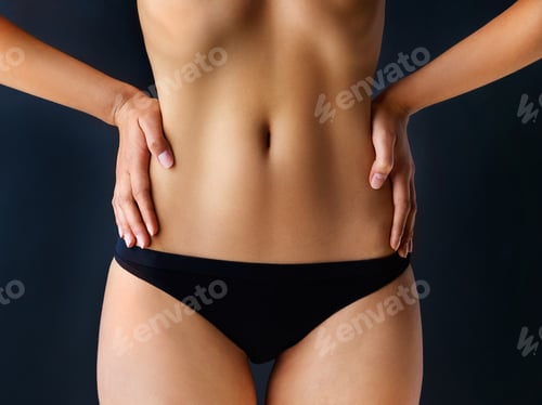 Preview: The perfect waist. Cropped shot of a beautiful young woman posing against a dark background.