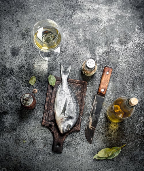 Preview: Fresh unprepared Dorado fish with white wine.