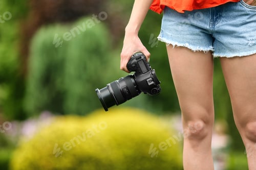 Preview: Photographer with professional camera in park, closeup. Space for text