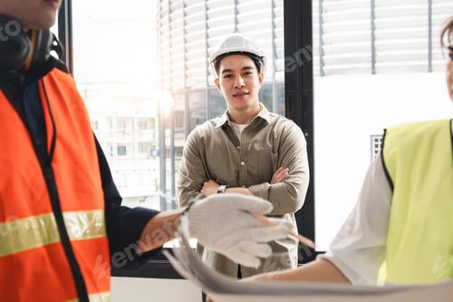 Preview: Handsome young chief engineer standing during engineer team discussion at construction site