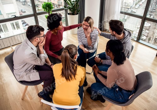 Vista previa: Diverse group of people sitting in circle in group therapy session.