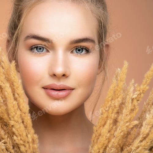 Preview: Blonde girl with a bunch spring dry field flowers near the face - over colored background.
