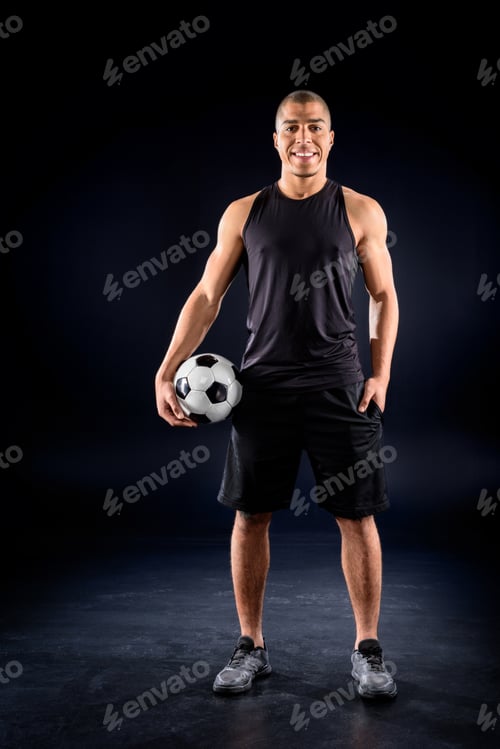 Preview: happy african american soccer player with ball on black