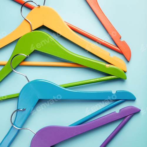 Preview: Five children's hangers for clothes of rainbow colors. Blue background.